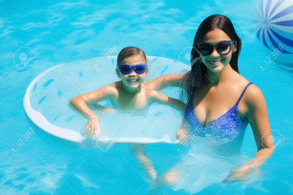 Little girl with her mom in swimming pool.