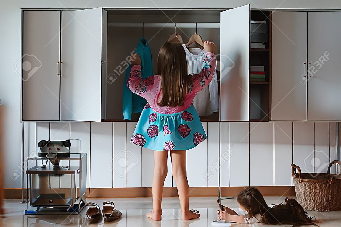 little girl opens the closet