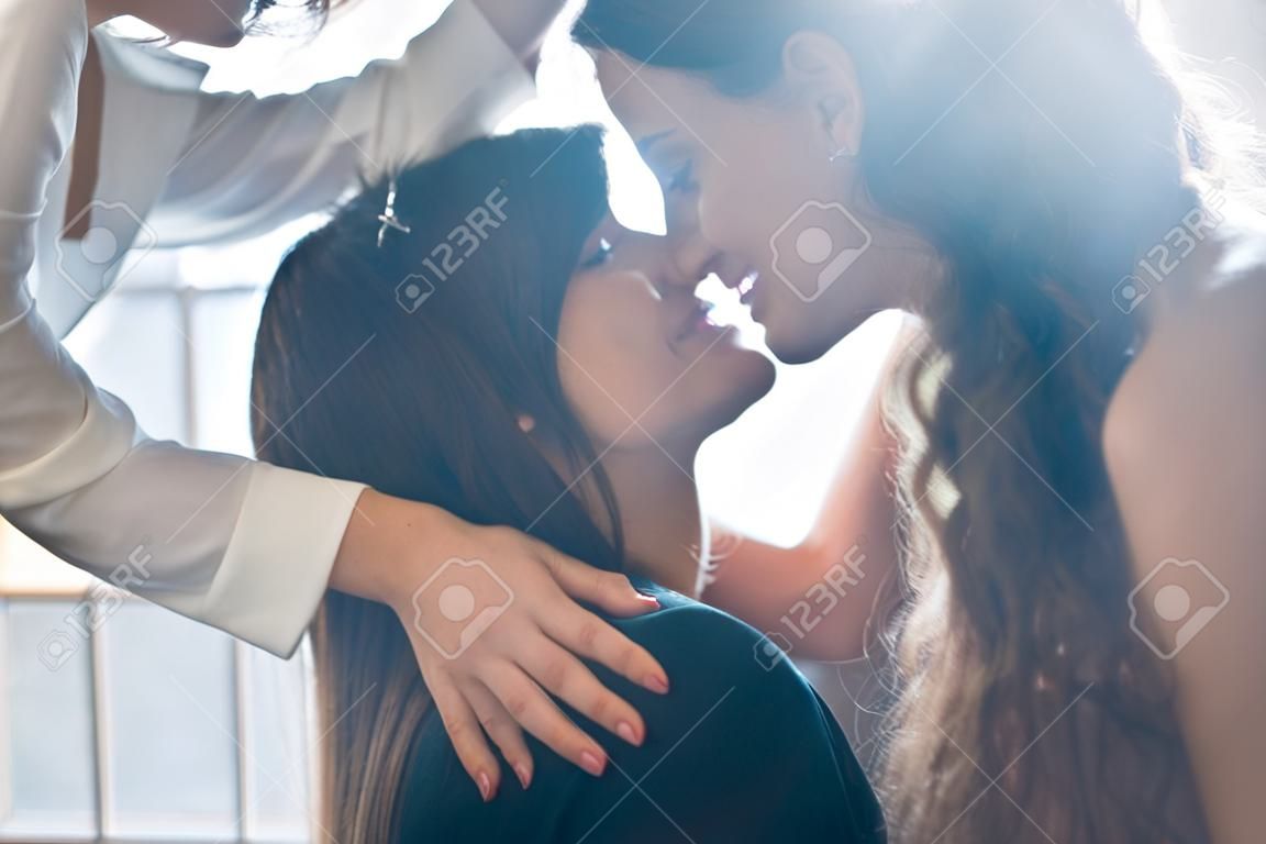 Nahaufnahme der jungen Frau, die nachdenklich Frau zu Hause küsst