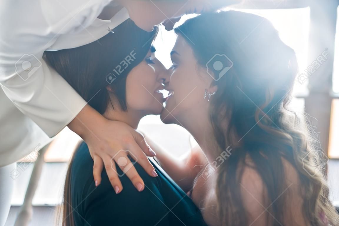 Cerrar joven mujer besando pensativamente a la mujer en casa