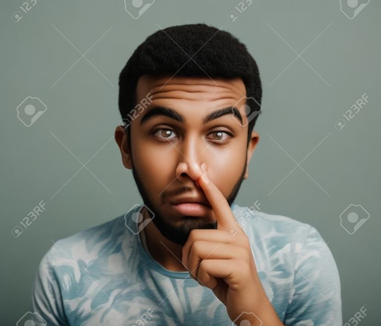 Young man with finger in his nose, picking the nostrils Stock Photo