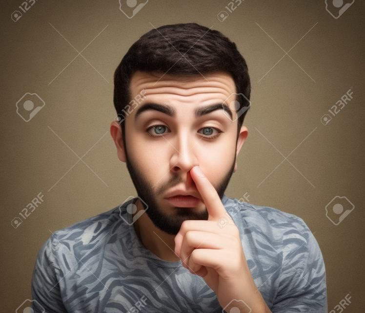 Young man with finger in his nose, picking the nostrils Stock Photo