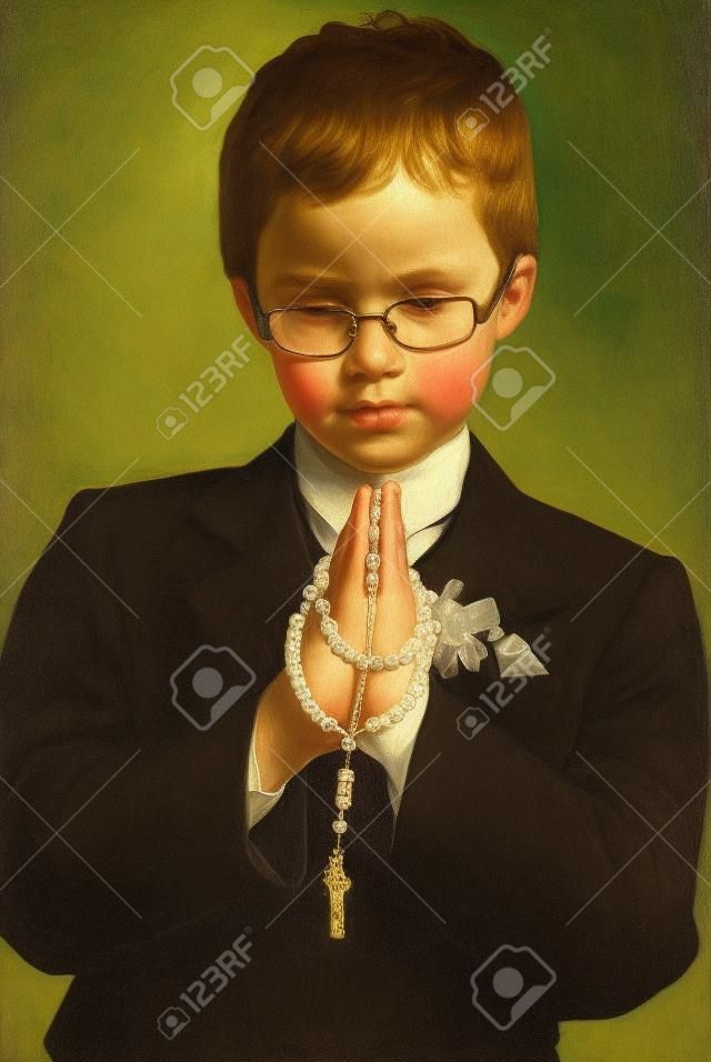 portrait du jeune garçon va à la première communion sainte de prier avec un rosaire