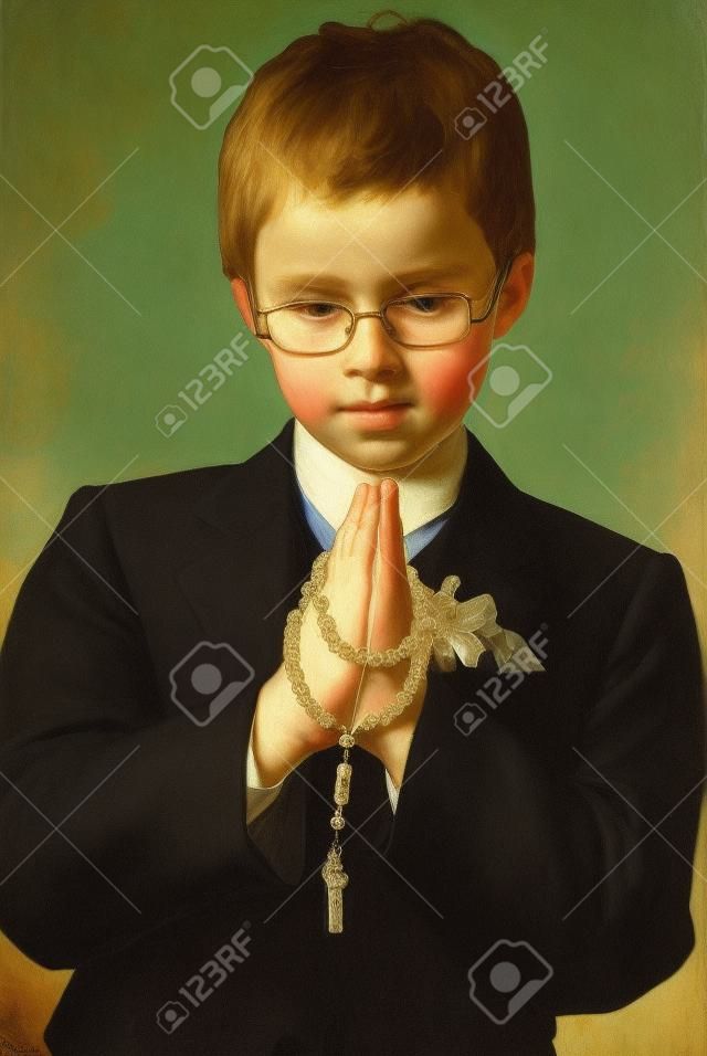 portrait du jeune garçon va à la première communion sainte de prier avec un rosaire