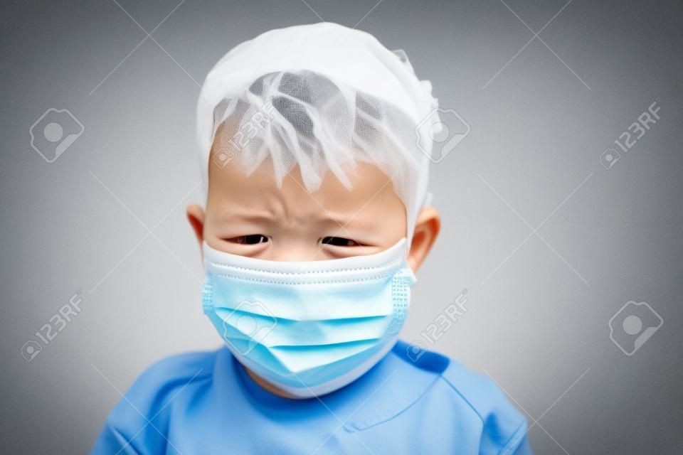 Crying toddler boy with medical mask on the face. Covid 2019 coronavirus outbreak. Sad child isolated on white. Boy at home
