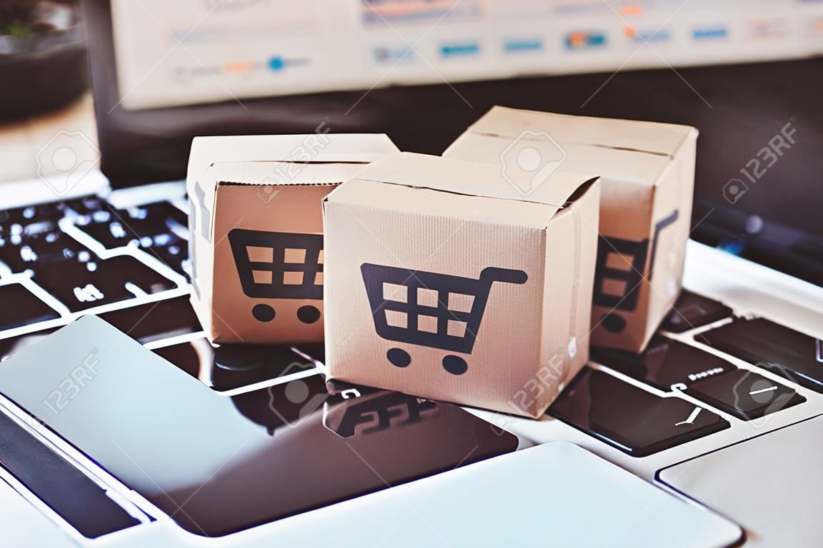 Shopping online. Credit card and cardboard box with a shopping cart logo on laptop keyboard. Shopping service on The online web. offers home delivery