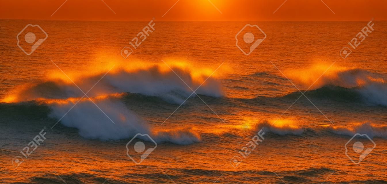 Golden onde che si infrangono al tramonto