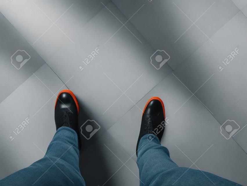 i piedi stanno sullo sfondo del pavimento bianco