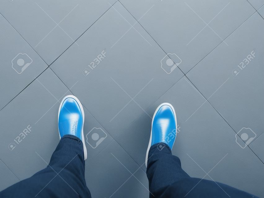 i piedi stanno sullo sfondo del pavimento bianco