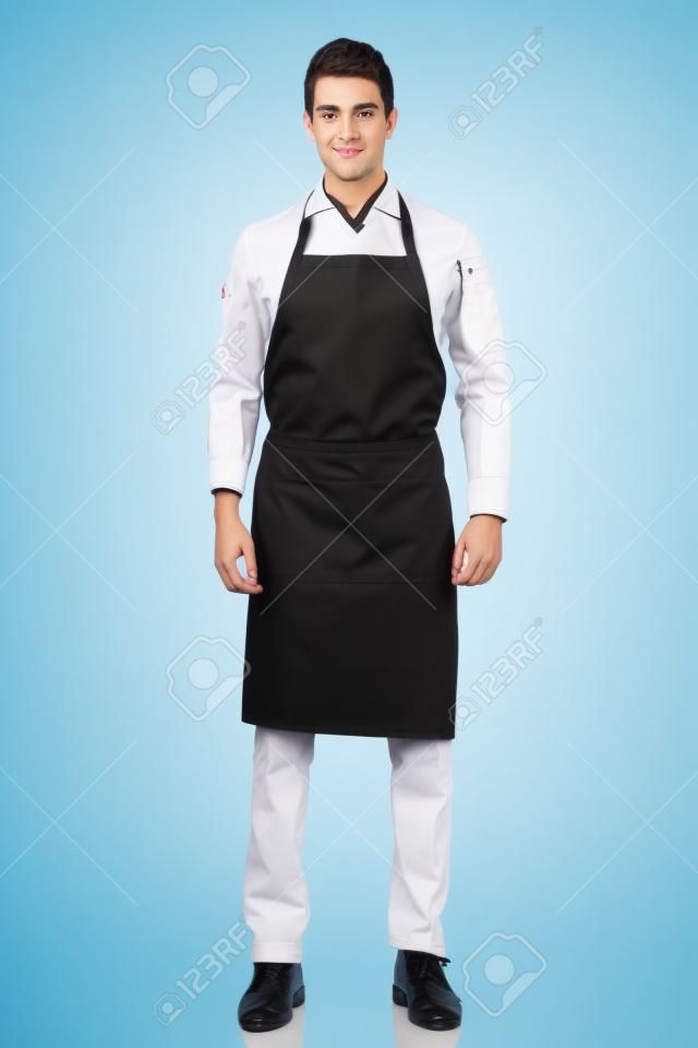 검은 앞치마와 흰색 셔츠를 입고 젊은 요리사 또는 웨이터 포즈의 전체 길이 샷, 흰색 배경에 고립
