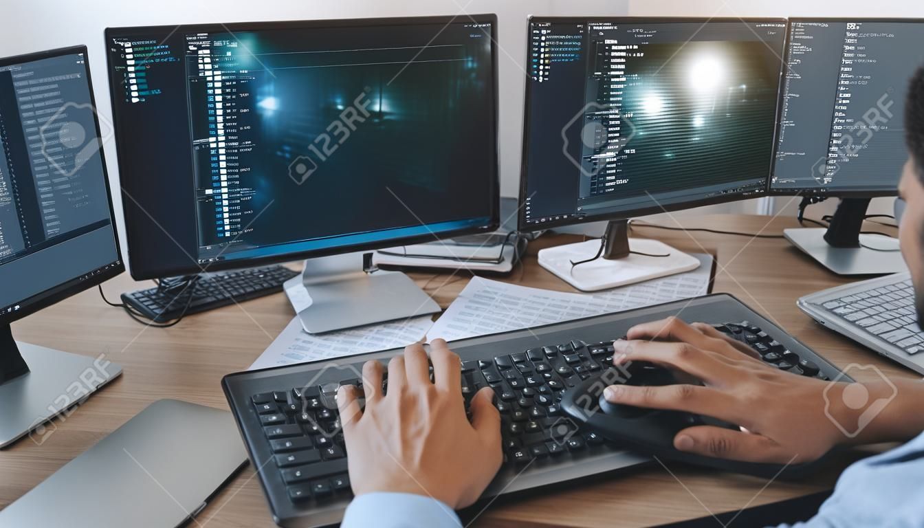 Programmatore che lavora sul computer in ufficio IT digitando la codifica dei dati nel software e controllando il codice sullo schermo del computer computer