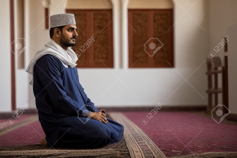 Uomo religioso musulmano seduto all'interno della moschea per pregare