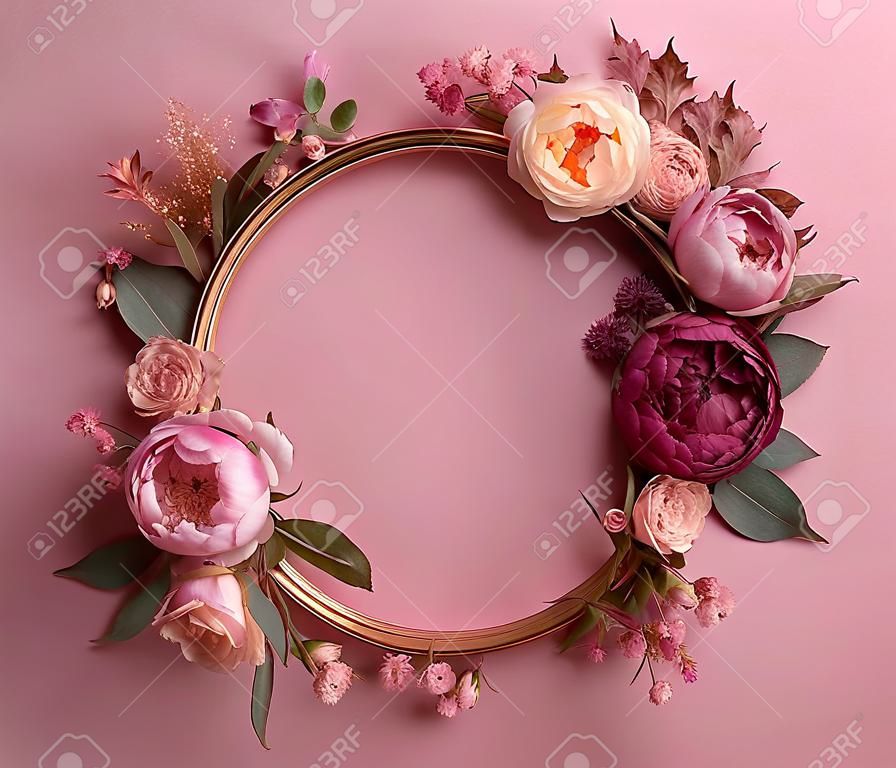 Okrągła ramka ozdobiona kwiatami i liśćmi na różowym tle tworzy uroczą i atrakcyjną wizualnie kompozycję
