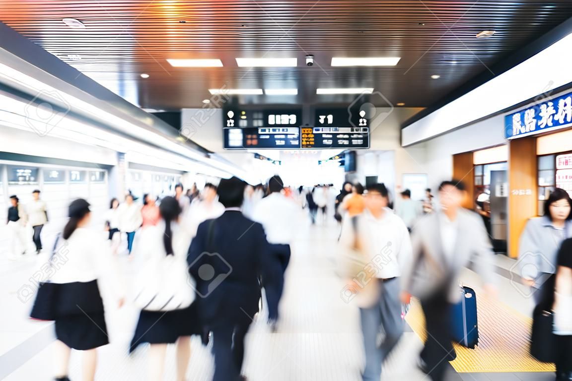 Passeggeri offuscati che camminano nel concetto di background aziendale della stazione ferroviaria di osaka