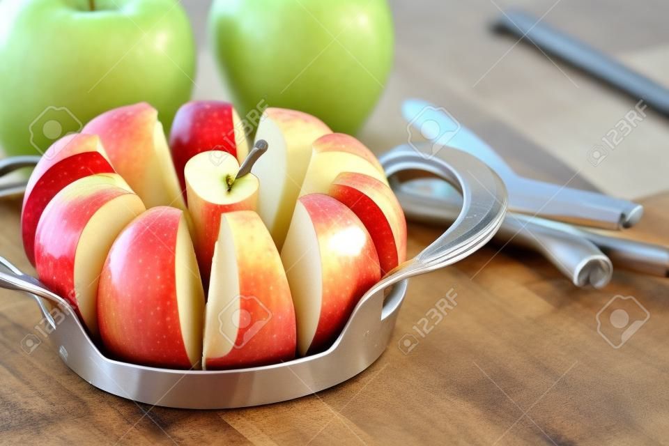 Uma maçã cortada é em cunhas e cored usando uma ferramenta de cozinha útil.