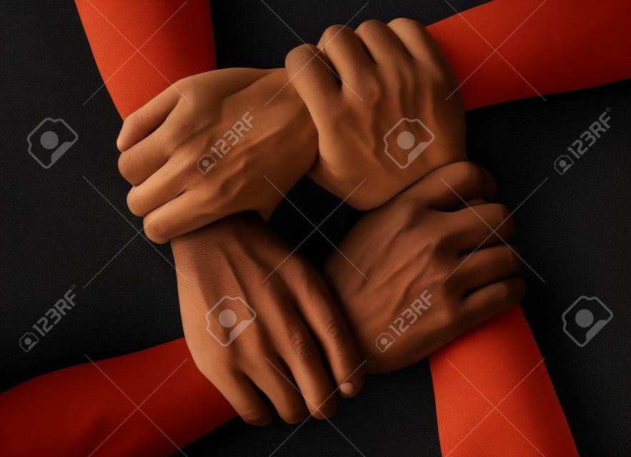 multiracial group with black african American Caucasian and Asian hands holding each other wrist in tolerance unity love and anti racism concept isolated on black background