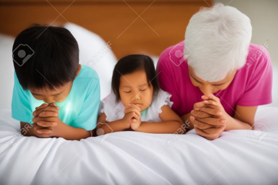 родители и дети молятся на кровати