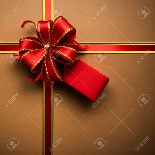 Rosso e fiocco regalo d'oro con un tag vuoto e nastri