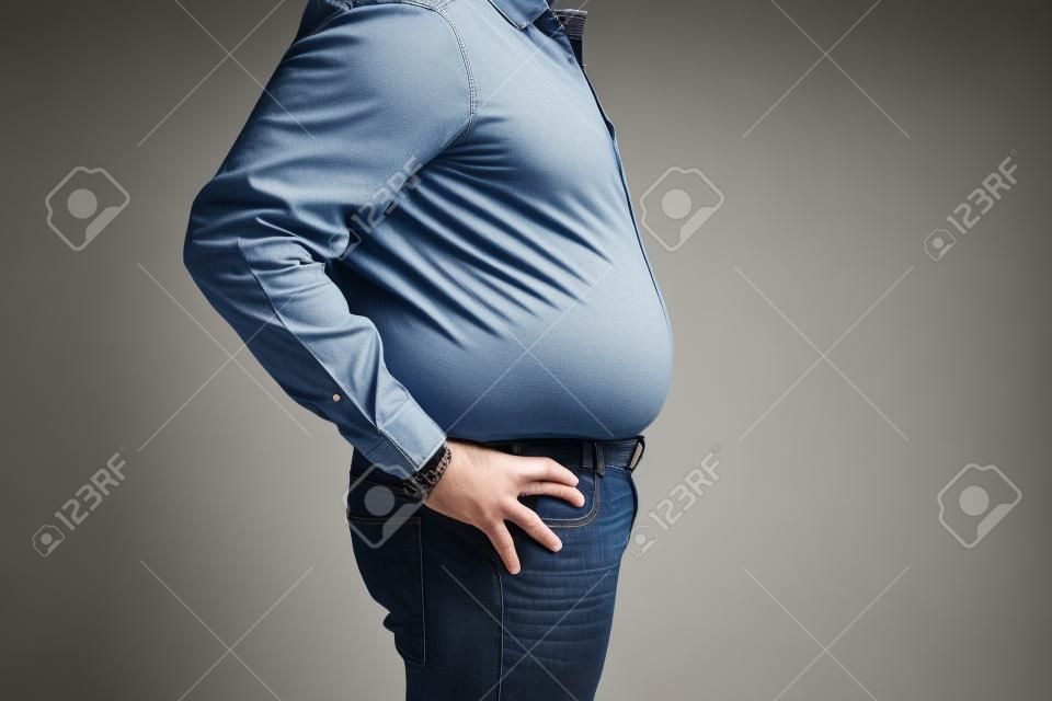 hombre con una barriga grande usando una camisa y jeans, vista lateral