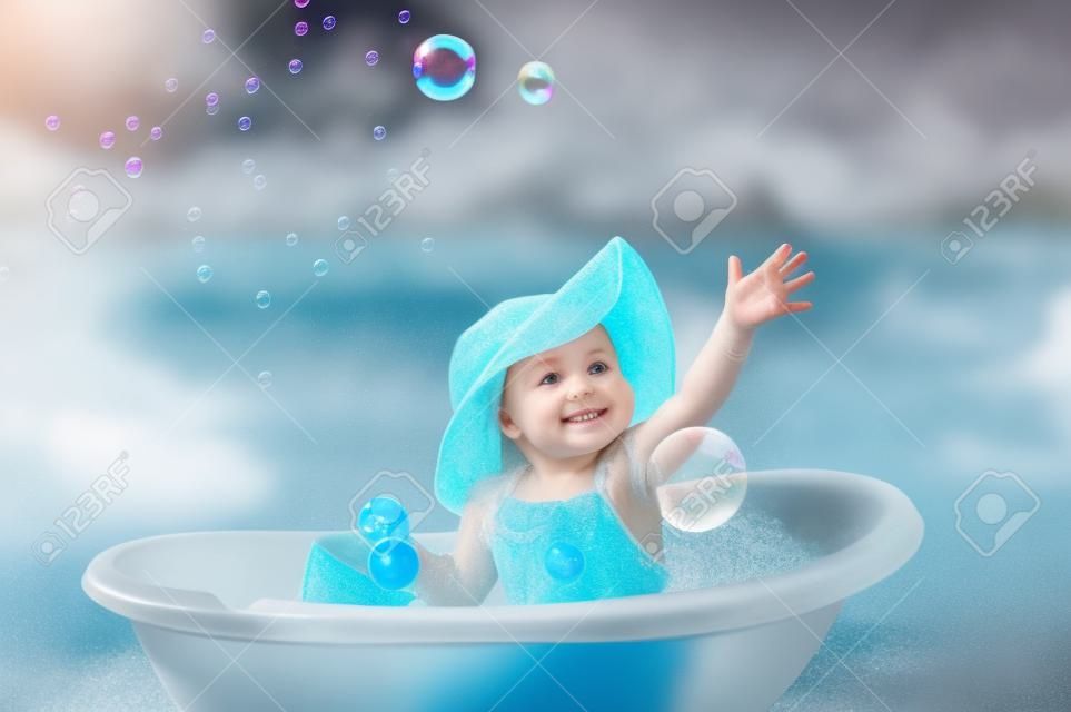 little girl bathes in a bath with soap bubbles.