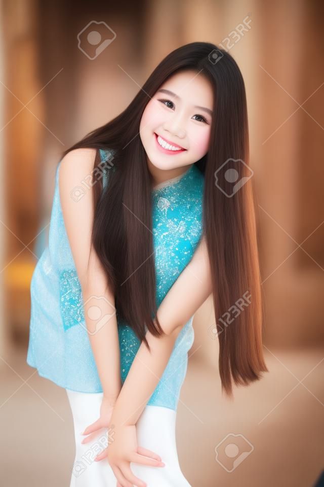 中国のドレスでタイの十代の美しい女の子の肖像画、リラックスして笑顔。