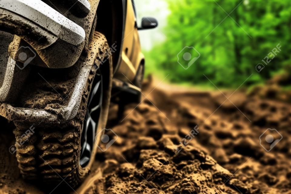 Auto fuoristrada sporca, SUV coperto di fango su strada di campagna, pneumatici fuoristrada, viaggi fuoristrada e concetto di guida.