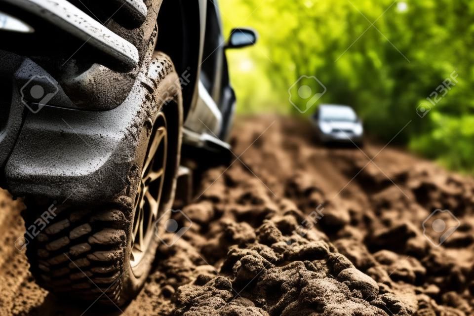 Auto fuoristrada sporca, SUV coperto di fango su strada di campagna, pneumatici fuoristrada, viaggi fuoristrada e concetto di guida.