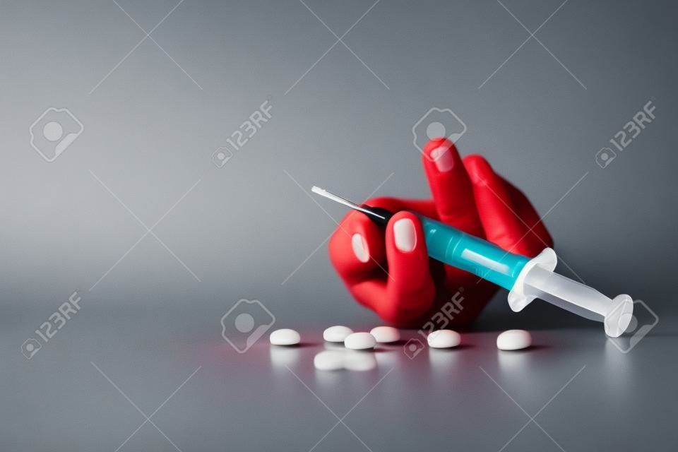 Woman hand of a drug addict and a syringe with narcotic syringe lying on the floor, Overdose, drug concept.