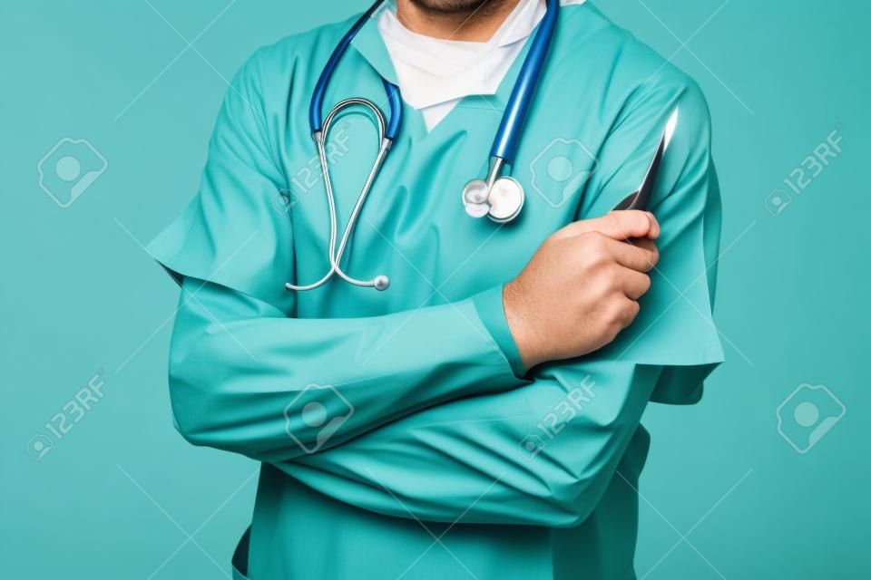 Orvos zöld egyenruhát, kezében egy szikét