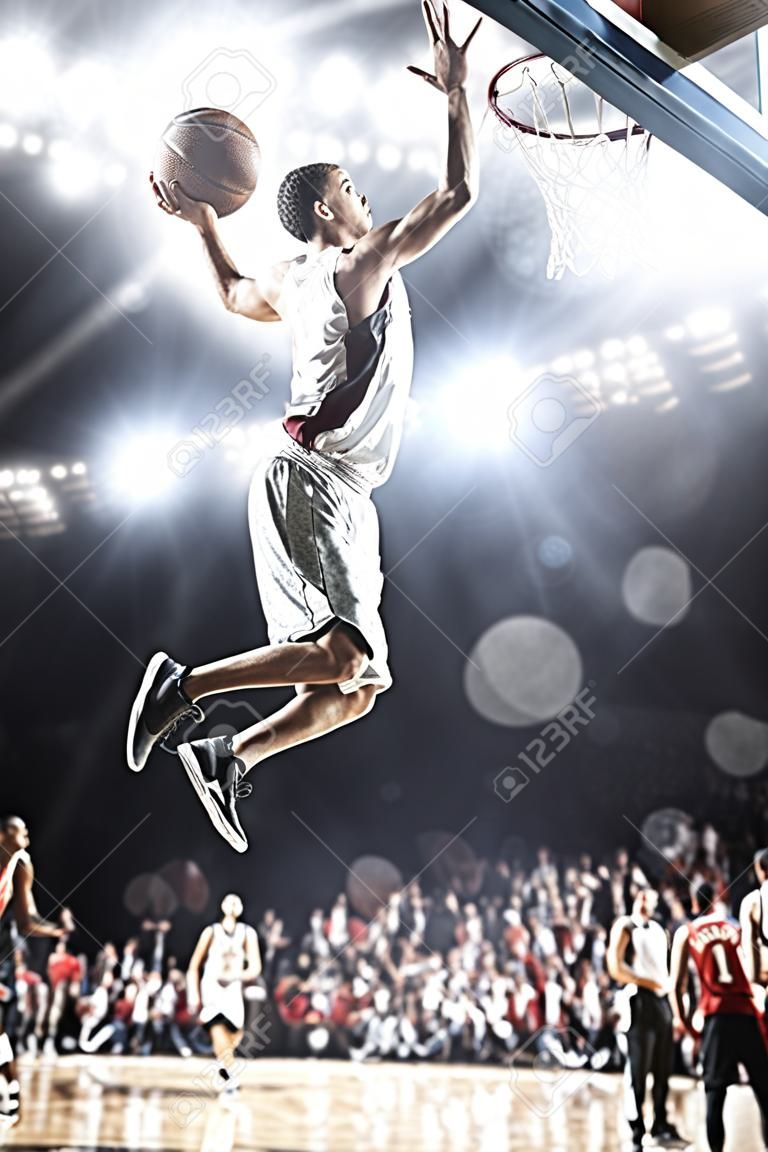 Giocatore di basket in azione volare alto e segnando