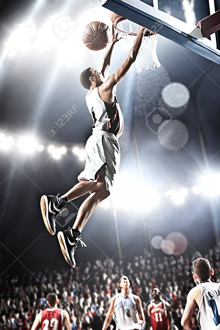 El jugador de baloncesto en la acción volando alto y anotando