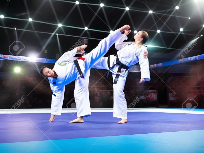 Two professional female karate fighters are fighting on the grand arena