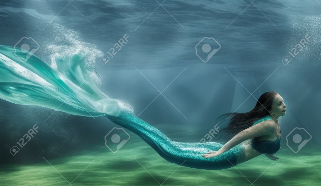 Frauen-Schwimmen wie eine Meerjungfrau Unterwasser Freien