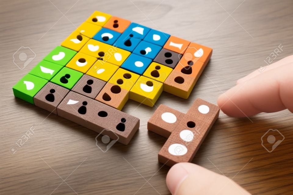 Imagen del concepto de negocio de bloques de rompecabezas de tangram con iconos de personas sobre mesa de madera, recursos humanos y concepto de gestión