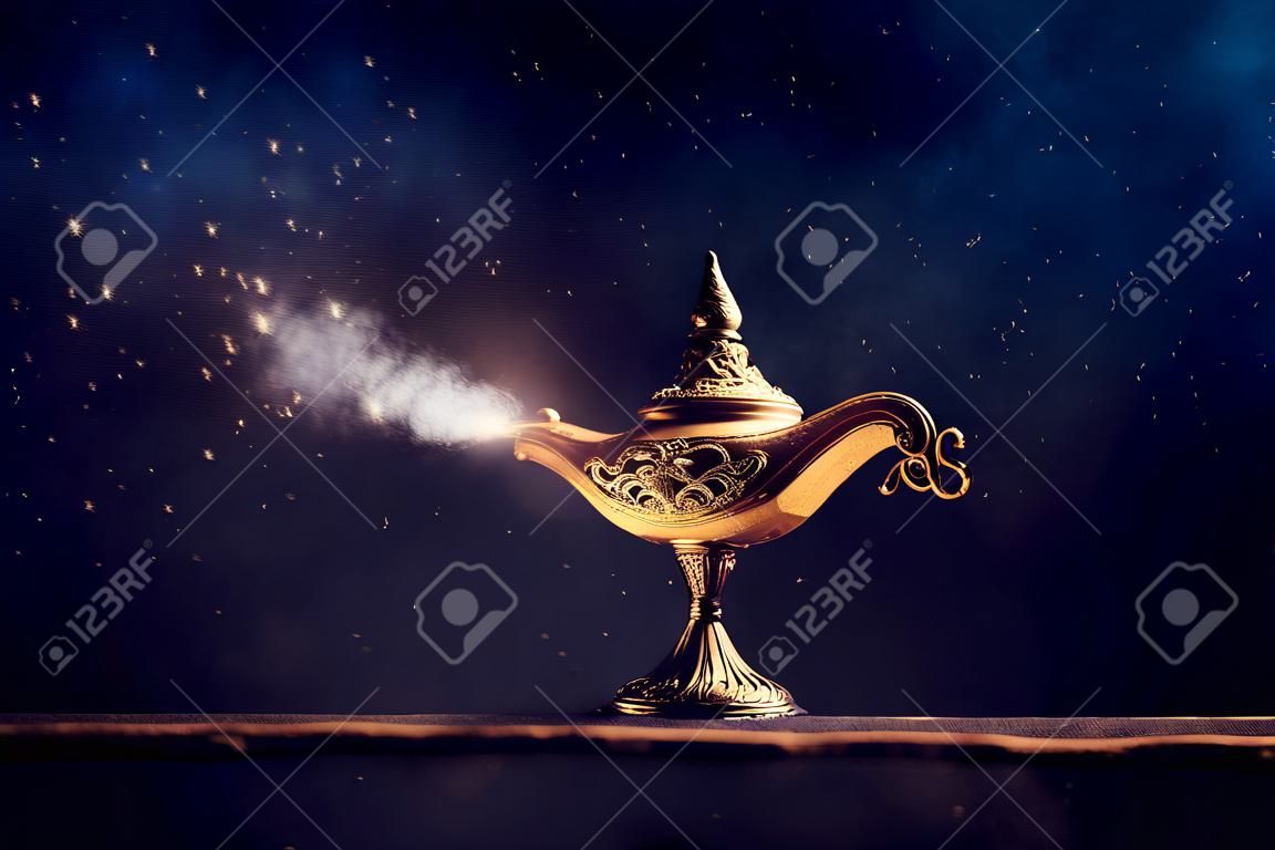 Imagen de la mágica y misteriosa lámpara de Aladdin con humo brillante sobre fondo negro lámpara de deseos