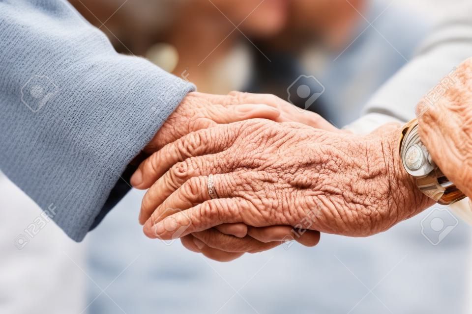 Couple de personnes âgées tenant les mains à l'extérieur