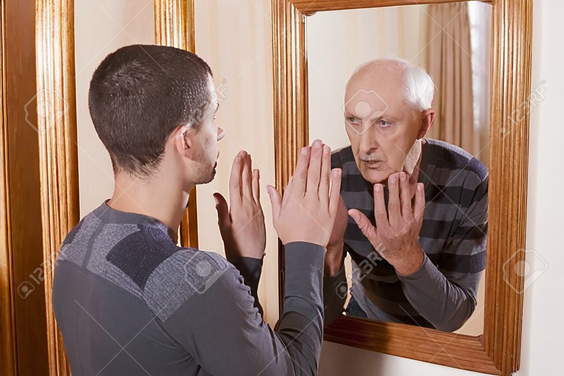 молодой человек, глядя на старшего на себя в зеркало