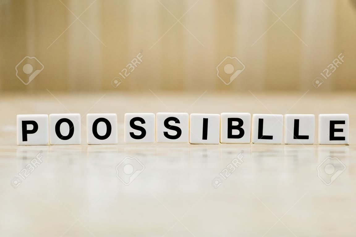 A row of small white plastic tiles, containing the letters forming the word possible, torepresents the concept of possibility, self-esteem and will.