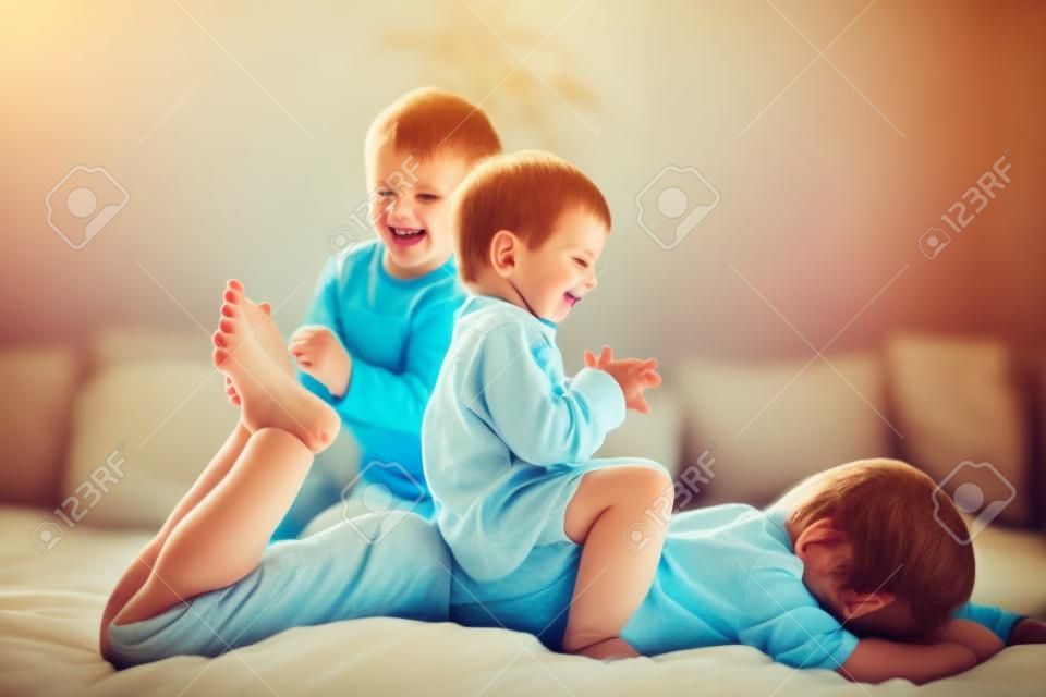 Bambini, fratelli, che giocano in casa, solleticano i piedi ridendo e sorridendo