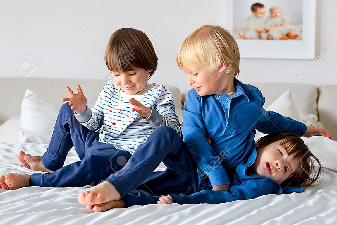 Enfants, frères, jouant à la maison, chatouillant les pieds en riant et en souriant