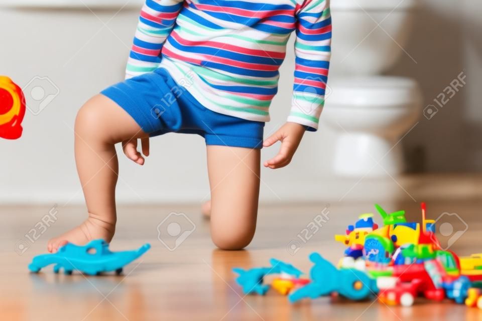 어린 아이, 소년, 장난감을 가지고 노는 동안 바지에 오줌을 싸고, 아이는 주의가 산만해지고 집에서 화장실에 가는 것을 잊어버린다
