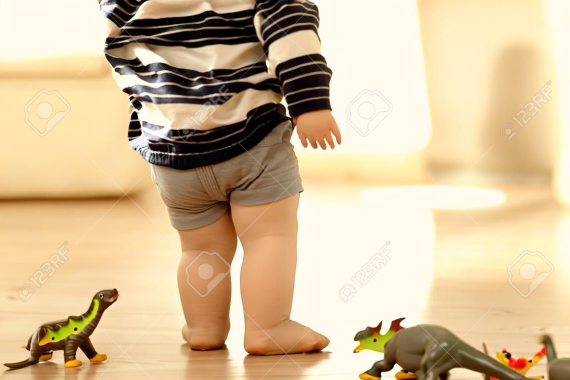 Little toddler child, boy, pee in his pants while playing with toys, child distracted and forget to go to the toilet at home