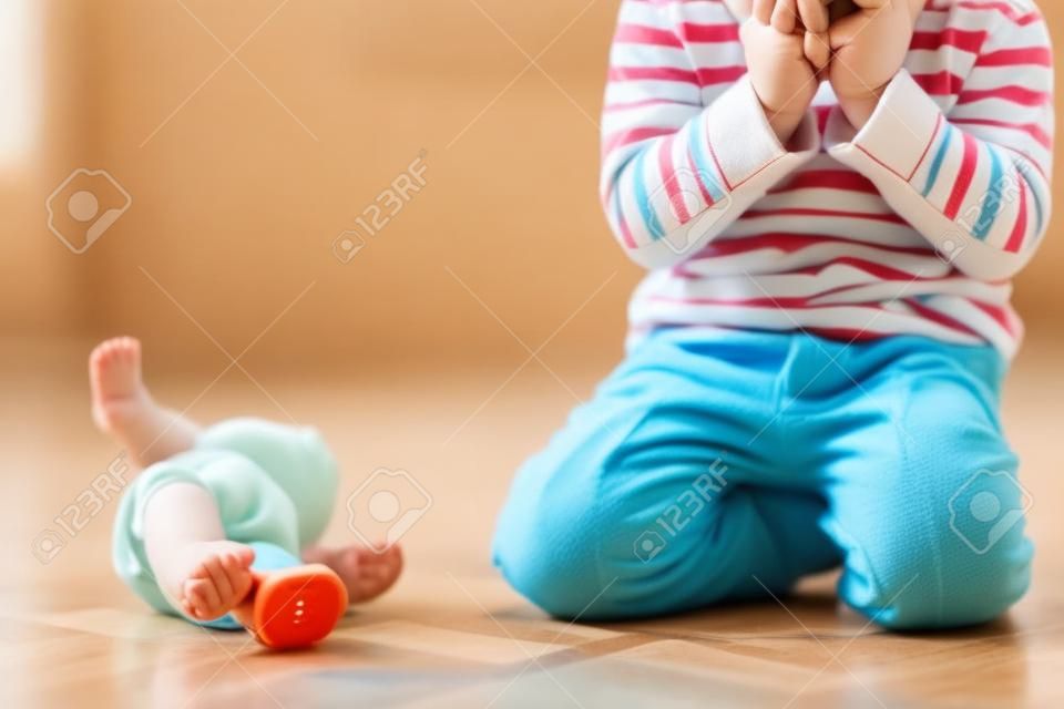 Criança pequena, menino, fazer xixi em suas calças enquanto brinca com brinquedos, criança distraída e esquecer de ir ao banheiro em casa