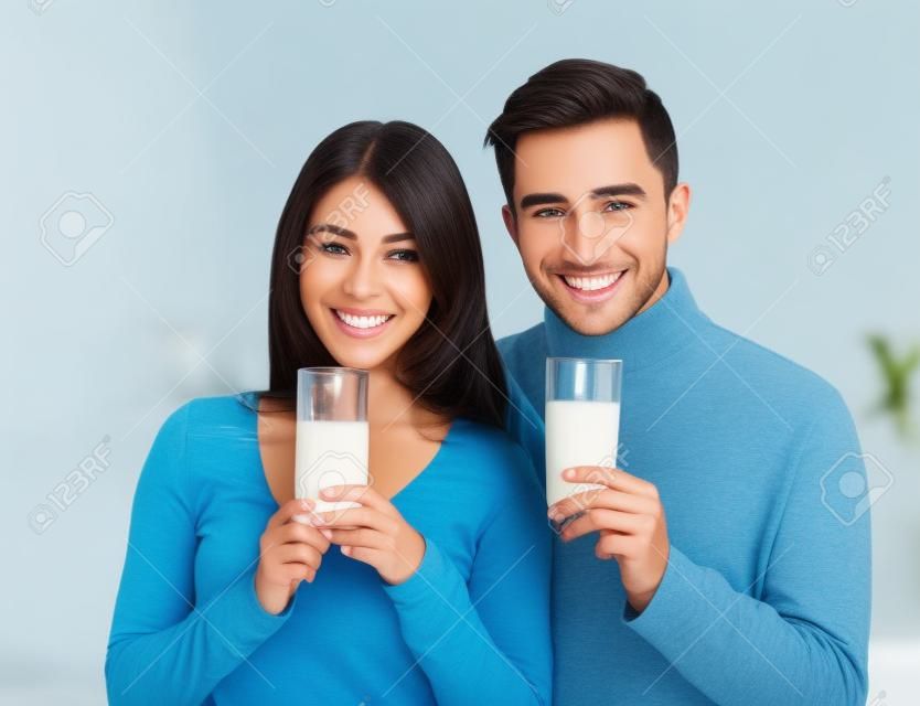 Young beautiful smiling couple drinking milk