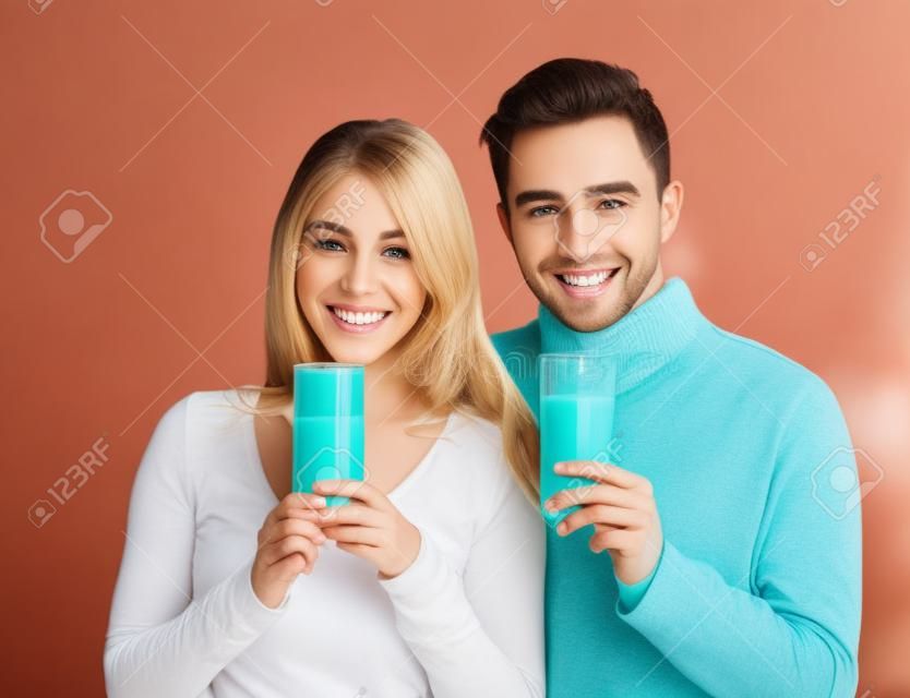 Young beautiful smiling couple drinking milk