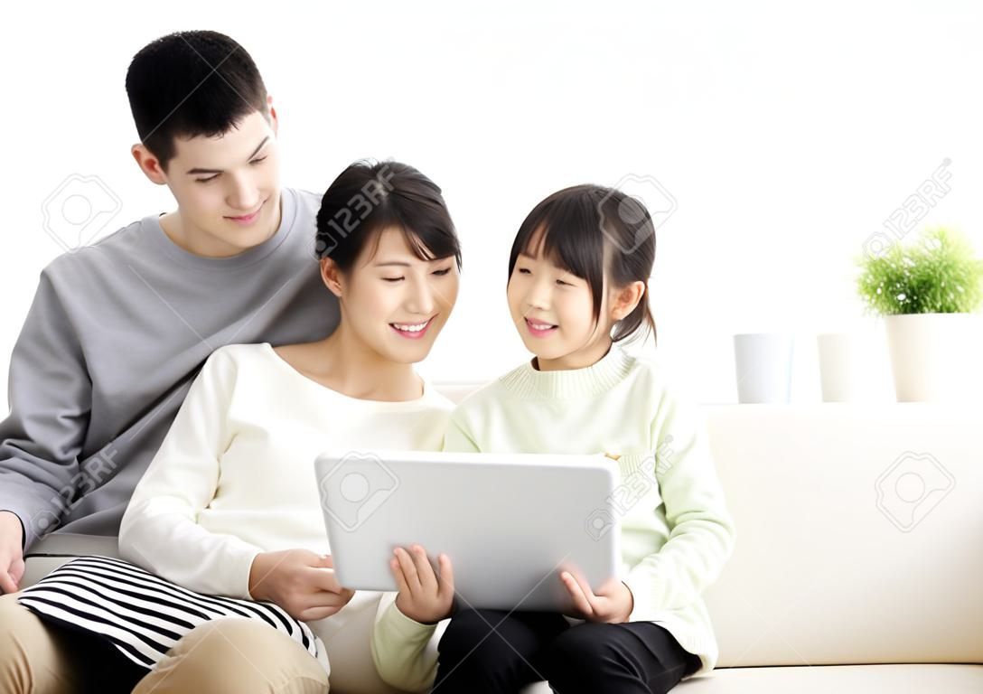 Glücklich attraktive junge Familie, die Tablette beobachten
