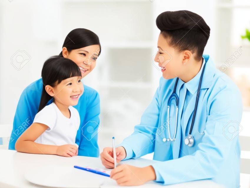 Młody lekarz mówi do małego dziecka i matki