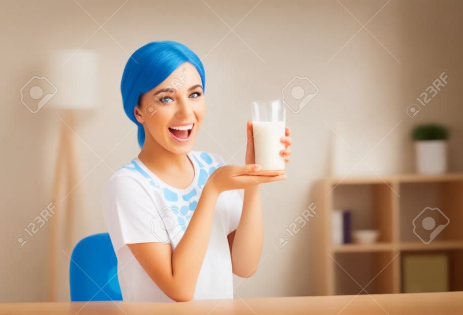 快樂的年輕女子喝牛奶