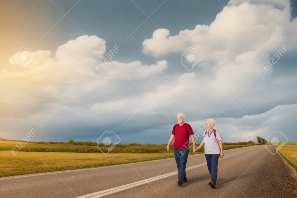 casal sênior caminhadas na estrada do país