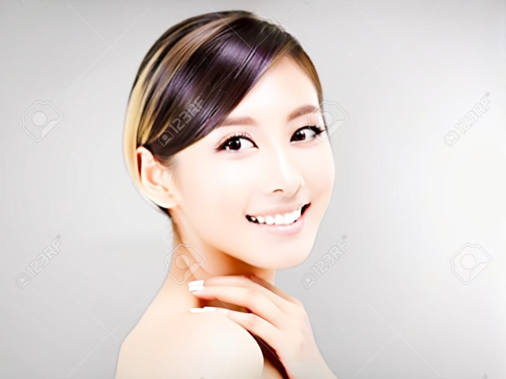 jonge glimlachende vrouw gezicht met grijze achtergrond